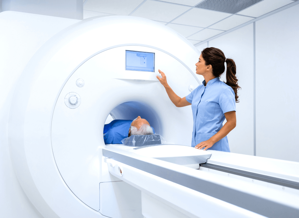 Medical professional assists a patient in an MRI scan room.